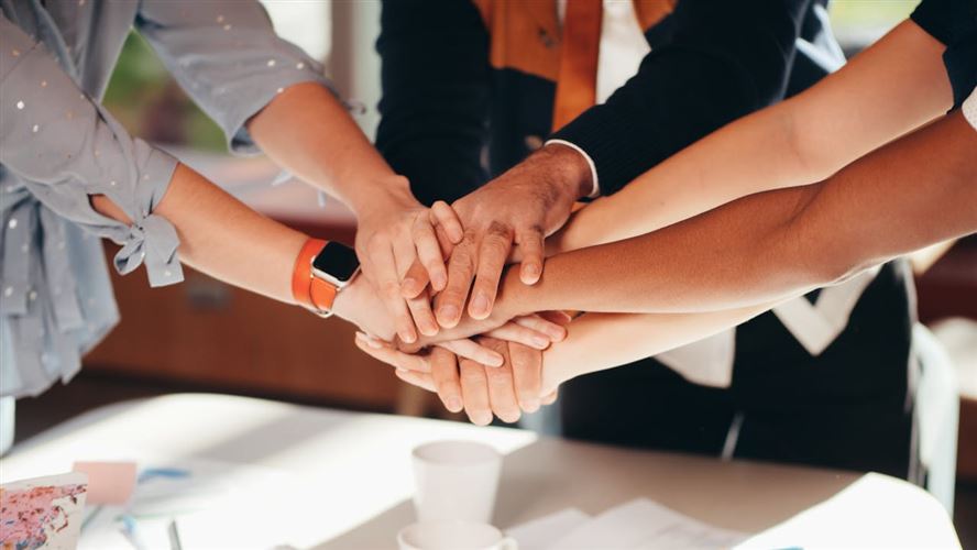 Koncernmedlemmar firar en konsolidering genom en fist bump.